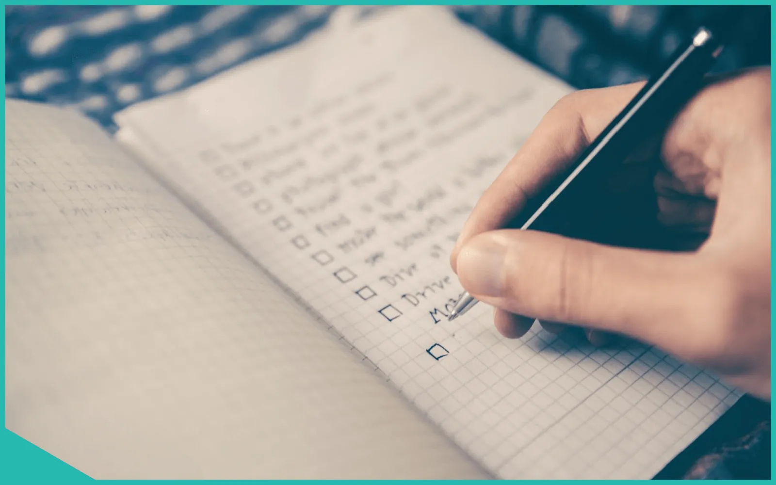 Persona escribiendo en un cuaderno mientras trabaja en una laptop